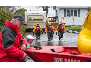 Firefighters check on a resident as the residents of Constance Bay deal with the Ottawa River rising to record levels and  flooding the region.