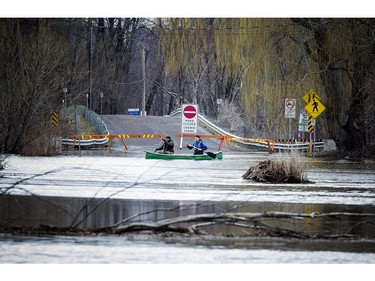 Flooding of the Ottawa River has caused the city to close Trim Road going into Petrie Island Saturday April 22, 2017. Paddlers L-R Oliver Bibeau and Chris Tyler make their way along where Trim Road would normally be.