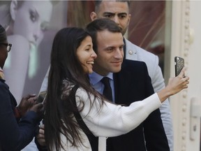 Newly elected French President Emmanuel Macron poses with a woman for a selfie picture as he leaves the hairdresser on May 9, 2017, in Paris. Justin Trudeau – another king of political selfies – is both a winner and a loser because of Macron's election, writes Andrew Cohen.