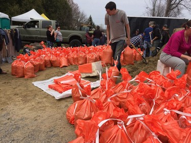 May 04- 2017.  Dozens of volunteers fill and carry sandbags in the fight to save homes along Voisine Road in Rockland.