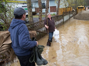Gaby Brisson (L) arrives to help his sister-in-law Kim Brant as she contemplates sandbaging around her home and bail out the basement as the residents of Constance Bay deal with the Ottawa River rising to record levels and  flooding the region.