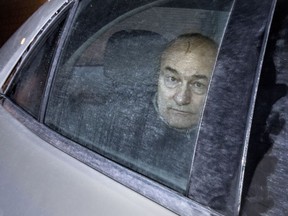 Ian Bush inside the back of of an unmarked police cruiser as it leaves the Elgin Steet courthouse in Ottawa, Friday, February 20, 2015.