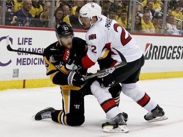 Pittsburgh Penguins' Jake Guentzel (59) and Ottawa Senators' Dion Phaneuf (2) battle in the corner during the second period of Game 5 in the NHL hockey Stanley Cup Eastern Conference finals, Sunday, May 21, 2017, in Pittsburgh.