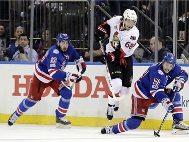 New York Rangers' Jesper Fast (19) fights for control of the puck with Ottawa Senators' Mike Hoffman (68) as Mika Zibanejad (93) watches during the second period of Game 4 of an NHL hockey Stanley Cup second-round playoff series Thursday, May 4, 2017, in New York.