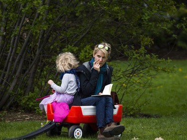 Jodie Mess sits with her daughter four-year-old Audrey Medd in Commissioners Park while the Canadian Tulip Festival took place Sunday May 14, 2017.  Ashley Fraser/Postmedia
