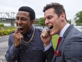 Juron Criner, left, and Greg Ellingson take a bite out of their 2016 Ottawa Redblacks Grey Cup rings during a ceremony at the Canadian Museum of History on Friday, May 26, 2017.