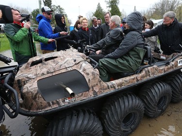 Kathleen Wynne and Jim Watson talk Michel and Maggie Bourbonnais on Morin rd in Cumberland with the flooded Ottawa river in the background, May 08, 2017. The Bourbonnais' house has been flooded.