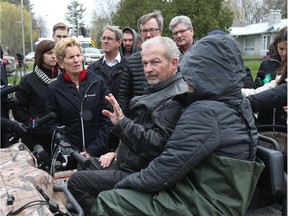 Kathleen Wynne and Jim Watson talk Michel and Maggie Bourbonnais on Morin rd in Cumberland with the flooded Ottawa river in the background, May 08, 2017. The Bourbonnais' house has been flooded.