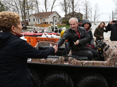Kathleen Wynne shakes the hand Michel and Maggie Bourbonnais on Morin Road in Cumberland with the flooded Ottawa river in the background, May 08, 2017. The Bourbonnais' house has been flooded.