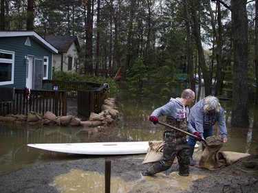 Kim Brant and a good friend fill sandbags to place around her home in Constance Bay. The area has been hit with major flooding May 6, 2017.   Ashley Fraser/Postmedia