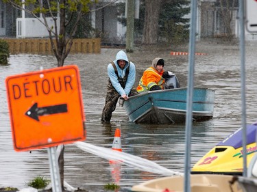 Local residents in a boat navigate the flooded Rue Saint-Louis in Gatineau as flooding continues throughout the region in areas along the local rivers.