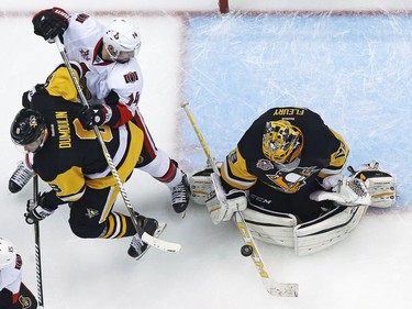 Pittsburgh Penguins goalie Marc-Andre Fleury (29) blocks a shot as Brian Dumoulin (8) keeps Ottawa Senators' Alex Burrows (14) from getting his stick on the rebound during the second period of Game 2 of the Eastern Conference final in the NHL Stanley Cup hockey playoffs in Pittsburgh, Monday, May 15, 2017. The Penguins won 1-0.