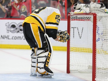 Marc-Andre Fleury checks his mask after a goal was scored on him in the first period as the Ottawa Senators take on the Pittsburgh Penguins in Game 3 of the NHL Eastern Conference Finals at the Canadian Tire Centre.  Wayne Cuddington/Postmedia