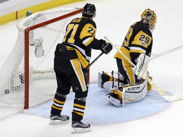 The Pittsburgh Penguins' Evgeni Malkin looks at the puck in the net behind goalie Marc-Andre Fleury after the Ottawa Senators' Jean-Gabriel Pageau scored.