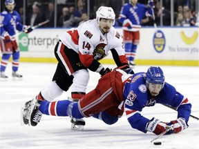 New York Rangers' Mika Zibanejad (93) and Ottawa Senators' Alex Burrows (14) fights for control of the puck during the second period of Game 6 of an NHL hockey Stanley Cup second-round playoff series Tuesday, May 9, 2017, in New York.