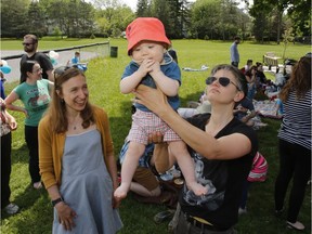 Mom, Carolyn Johanson, right, Lia, 6 months, and midwife Marissa Charbonneau, left, take part in a midwife picnic at McKellar Park in Ottawa on Sunday, May 28, 2017.