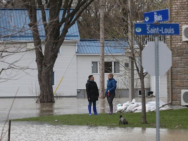 Gatineau emergency workers helped the people of Rue Saint-Louis in Gatineau Wednesday May 3, 2017. More rain has caused water to rise and flooded more people out of their homes. Two women take their dog out for a walk Wednesday.