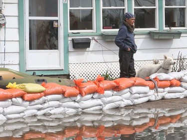 Gatineau emergency workers helped the people of Rue Saint-Louis area in Gatineau Thursday May 4, 2017. More rain has caused water to rise and flooded more people out of their homes. A woman and her dog examine the flooding on Rue Jacques-Cartier Thursday.