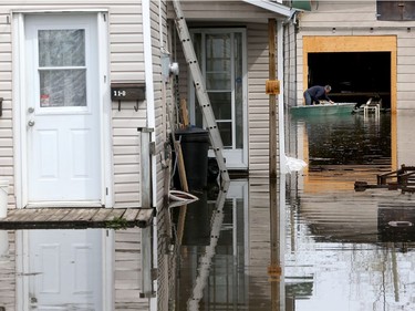 Gatineau emergency workers helped the people of Rue Saint-Louis area in Gatineau Thursday May 4, 2017. More rain has caused water to rise and flooded more people out of their homes. A man works on his boat in his backyard Thursday.