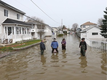 Gatineau emergency workers helped the people of Rue Saint-Louis area in Gatineau Thursday May 4, 2017. More rain has caused water to rise and flooded more people out of their homes. Neighbours examine the flooding on Rue Jacques-Cartier Thursday.
