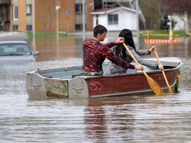 Gatineau emergency workers helped the people of Rue Saint-Louis area in Gatineau Thursday May 4, 2017. More rain has caused water to rise and flooded more people out of their homes. A couple use a boat to get down Rue Saint-Louis in Gatineau Thursday.