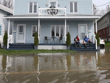 Gatineau emergency workers helped the people of Rue Saint-Louis area in Gatineau Thursday May 4, 2017. More rain has caused water to rise and flooded more people out of their homes. Two friends take a break as they sit on their front steps on Rue Jacques-Cartier Thursday.