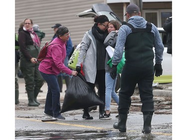 Water is starting to drop around Rue Saint-Louis in Gatineau Tuesday May 9, 2017. Home owners around the Gatineau area can only wait until the water goes away before the clean up can begin. Two women hug before leaving Rue Saint-Louis in Gatineau Tuesday.