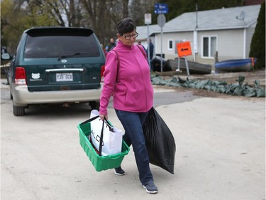 Water is starting to drop around Rue Saint-Louis in Gatineau Tuesday May 9, 2017. Home owners around the Gatineau area can only wait until the water goes away before the clean up can begin. A woman leaving with some belongings on Rue Saint-Louis in Gatineau Tuesday.