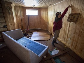 Nick Cai points to the level where flood waters rose in the basement of his house in the Pierrefonds borough of Montreal, Friday, May 12, 2017. A dam was built overnight to help drain the neighbourhood with residents returning to their homes.