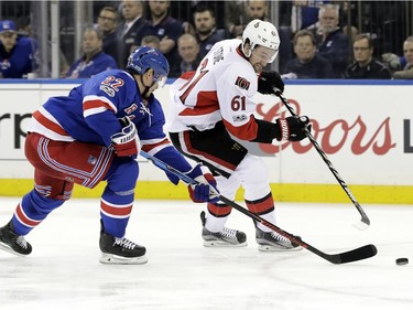 New York Rangers' Nick Holden (22) and Ottawa Senators' Mark Stone (61) reach for the puck during the first period of Game 3 of an NHL hockey Stanley Cup second-round playoff series Tuesday, May 2, 2017, in New York.