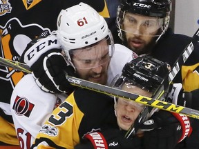 Pittsburgh Penguins' Olli Maatta (3) and Nick Bonino, top, tangle with Ottawa Senators' Mark Stone (61) during the third period of Game 2 of the Eastern Conference final in the NHL hockey Stanley Cup playoffs, Monday, May 15, 2017, in Pittsburgh. The Penguins won 1-0.