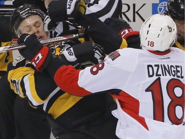 The Penguins' Olli Maatta is checked along the boards by Ottawa's Ryan Dzingel.