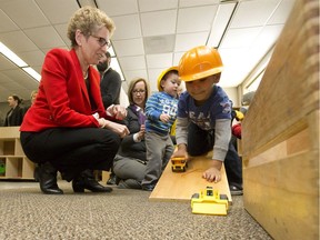 Ontario premier Kathleen Wynne plays with Marcus Sztrum as she tours the White Oaks Family Centre in London, Ont. on Friday February 19, 2016.