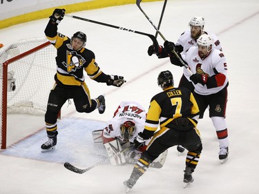 Ottawa Senators goalie Craig Anderson (41) blocks the puck as Pittsburgh Penguins' Jake Guentzel (59) and Kyle Turris (7) approach the goal against Ottawa Senators' Fredrik Claesson (33) and Cody Ceci (5) during overtime of Game 7 of the Eastern Conference final in the NHL Stanley Cup hockey playoffs in Pittsburgh, Thursday, May 25, 2017.