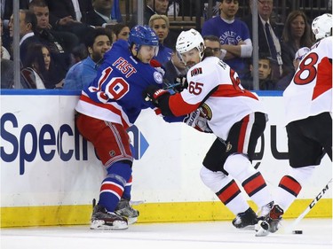 Jesper Fast of the New York Rangers battles with Erik Karlsson of the Ottawa Senators during the first period in Game 4.