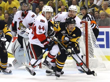 Sidney Crosby skates for the puck against Jean-Gabriel Pageau.