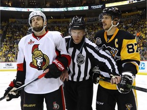 Linesman Brian Murphy breaks up Chris Wideman of the Ottawa Senators and Sidney Crosby of the Pittsburgh Penguins.