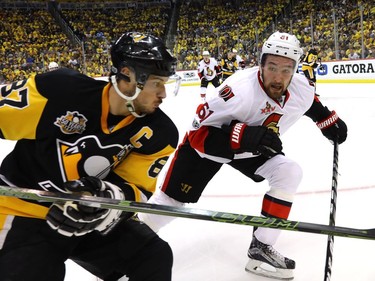Sidney Crosby of the Pittsburgh Penguins skates for the puck against Mark Stone of the Ottawa Senators.