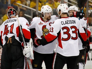Erik Karlsson of the Ottawa Senators celebrates with Craig Anderson and Fredrik Claesson after the overtime win.