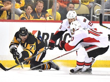 Evgeni Malkin #71 of the Pittsburgh Penguins fights for the puck against Zack Smith #15 and Tom Pyatt #10 of the Ottawa Senators during the first period in Game Seven of the Eastern Conference Final during the 2017 NHL Stanley Cup Playoffs at PPG PAINTS Arena on May 25, 2017 in Pittsburgh, Pennsylvania.