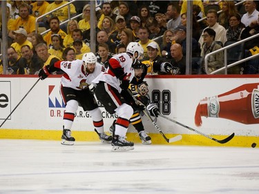 Brian Dumoulin #8 of the Pittsburgh Penguins fights for the puck against Derick Brassard #19 and Zack Smith #15 of the Ottawa Senators during the first period in Game Seven of the Eastern Conference Final during the 2017 NHL Stanley Cup Playoffs at PPG PAINTS Arena on May 25, 2017 in Pittsburgh, Pennsylvania.