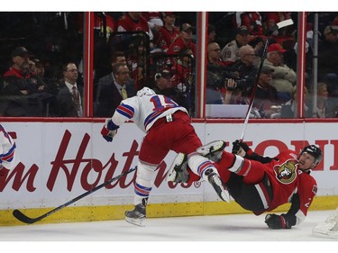 The Ottawa Senators' Dion Phaneuf gets hit by the New York Rangers; Tanner Glass.