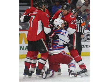 The Ottawa Senators' Chris Neil pesters the New York Rangers' Tanner Glass during the second period.