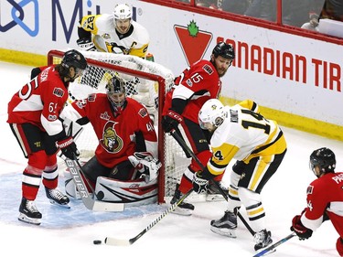 Pittsburgh Penguins left wing Chris Kunitz (14) shoots on Ottawa Senators goalie Craig Anderson (41) as Senators defenceman Erik Karlsson (65) and Senators centre Zack Smith (15) defend during the first period of game six of the Eastern Conference final in the NHL Stanley Cup hockey playoffs in Ottawa on Tuesday, May 23, 2017.