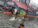 Volunteers pile orange sandbags around the Lighthouse Grocery and Restaurant on Bayview Drive, a community hub for generations in Constance Bay. 
