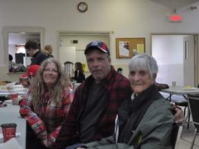 Pam Komm, 82, sits with family members at the Pontiac community centre Sunday, just moments after evacuating her home.