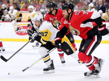 Sidney Crosby and Marc Methot chase the puck in the second period.
