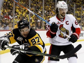 Pittsburgh Penguins' Sidney Crosby (87) and Ottawa Senators' Erik Karlsson look for the puck from along the boards during the second period of Game 2 of the Eastern Conference final in the NHL hockey Stanley Cup playoffs, Monday, May 15, 2017, in Pittsburgh.