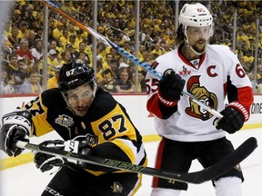 Pittsburgh Penguins' Sidney Crosby (87) and Ottawa Senators' Erik Karlsson look for the puck from along the boards during the second period of Game 2 of the Eastern Conference final in the NHL hockey Stanley Cup playoffs, Monday, May 15, 2017, in Pittsburgh.