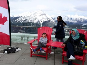 Syrian refugee Lina Hejazi and her kids, Khaled Hussain, 6, left, and Lara Hussain, 10, enjoy the views of Sulphur Mountain in Banff National Park in March, 2017. (Photo: Leah Hennel/Postmedia)
